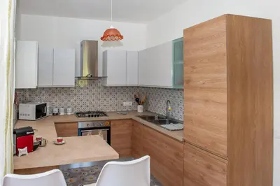 a kitchen with white cabinets and a counter top at AL BARONE in Scopello