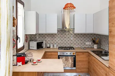 a kitchen with white cabinets and a counter top at AL BARONE in Scopello