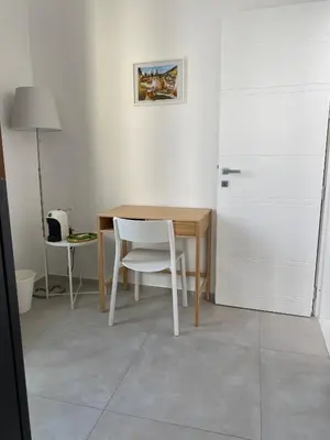 a kitchen with a table and a chair and a refrigerator at GIADA in Castellammare del Golfo