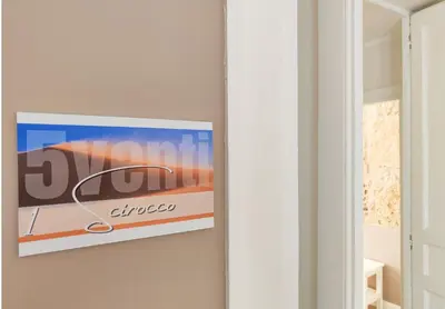 a sign hanging on a wall next to a door at Dimora Carella Ai 5Venti in Palermo
