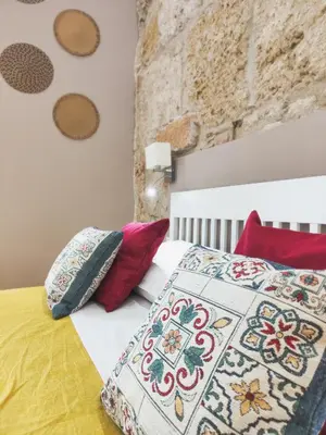 a bedroom with a bed with colorful pillows at Dimora Carella Ai 5Venti in Palermo