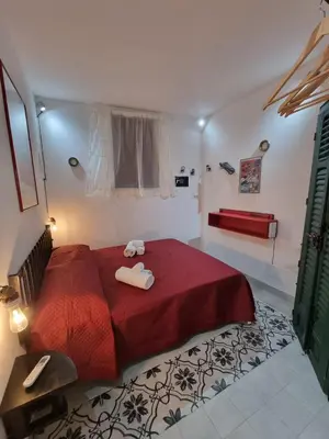 a bedroom with a red bed with two towels on it at Casa viotti Le fuoriserie in Palermo