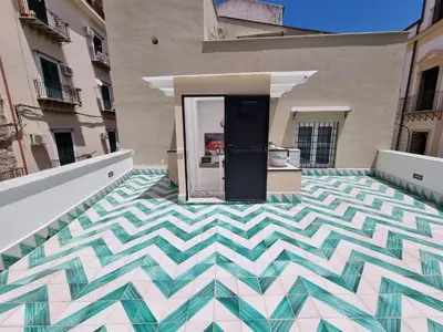 a house with a checkered floor in a courtyard at Casa viotti Le fuoriserie in Palermo