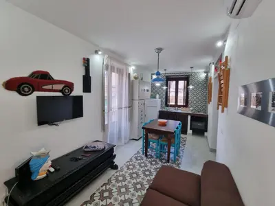 a living room with a couch and a red car on the wall at Casa viotti Le fuoriserie in Palermo