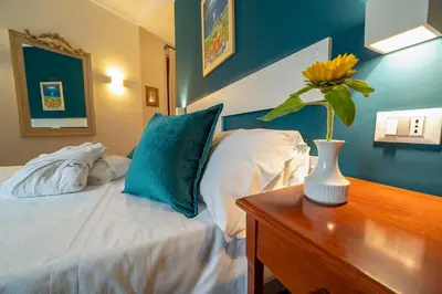 a bedroom with a bed and a vase with a flower on a table at Hotel Vecchio Borgo in Palermo