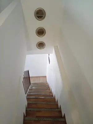 a staircase in a building with white walls and wooden stairs at Mi casa es tu casa in Palermo