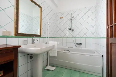 a bathroom with a sink and a tub and a mirror at Villa vista mare con piscina privata a Mondello in Palermo