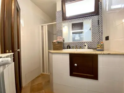 a bathroom with a sink and a tv on the wall at Baglio Giganti in Alcamo