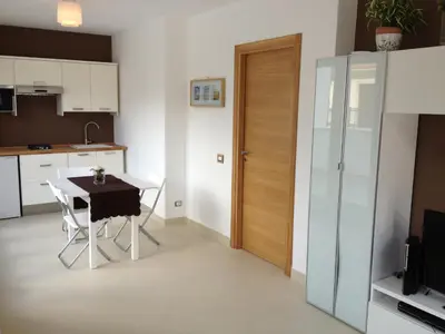 a kitchen with a table and chairs and a door at Mondello Suites FLH - Gorgonia in Mondello