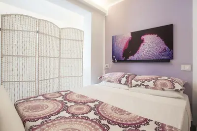 a bedroom with a bed with a painting on the wall at Mondello Suites FLH - Gorgonia in Mondello