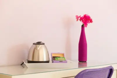 a vase with a pink flower on a desk at Mondello Suites FLH - Gorgonia in Mondello
