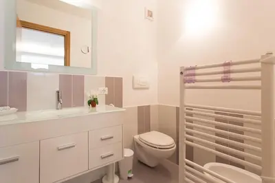 a bathroom with a toilet and a sink and a mirror at Mondello Suites FLH - Gorgonia in Mondello