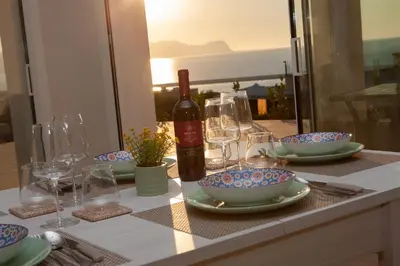 a table with a bottle of wine and bowls and glasses at Villa Lombardo Luxury in Balestrate