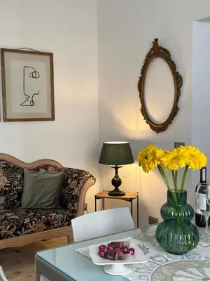 a living room with a table with a vase of yellow flowers at Maison Opéra in Palermo
