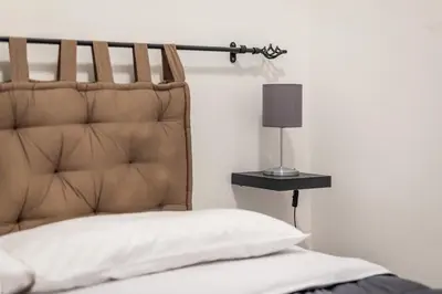 a bed with a headboard and a lamp on a table at Sicilia Bella Maqueda in Palermo