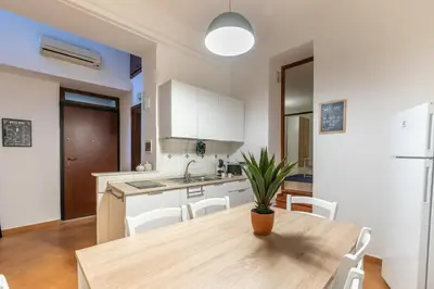 a kitchen with a wooden table and white cabinets at Sicilia Bella Maqueda in Palermo