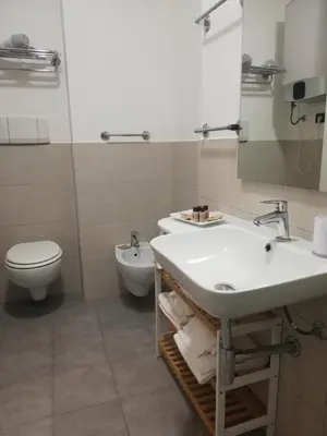 a white bathroom with a sink and a mirror at 215 addaura luxury room in Palermo