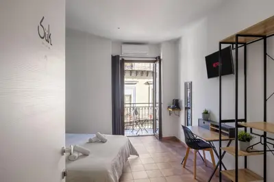 a bedroom with a bed and a table and a desk at Suk Ballarò in Palermo