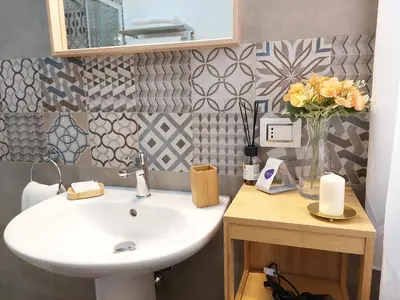 a bathroom with a sink and a vase of flowers at Sunset House in Balestrate