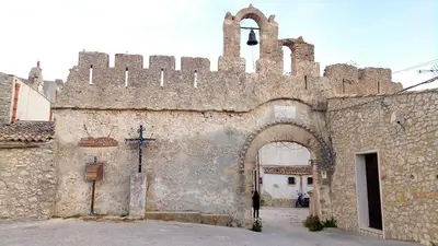 an old stone building with an archway and a tower at La Rosa Dei Venti in Castellammare del Golfo