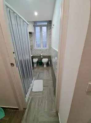 a small bathroom with a toilet and a window at Casa mulini in Palermo