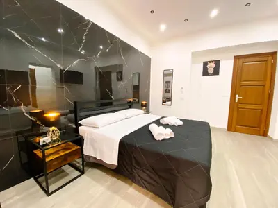 a bedroom with a black and white bed and a table at Aliva suite LT in Palermo
