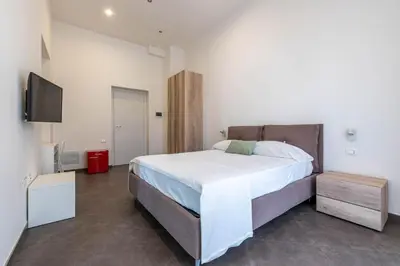a bedroom with a large bed and a flat screen tv at Apartments La Cala by Wonderful Italy in Palermo