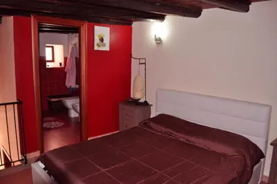 a bedroom with a bed and a red wall at Kalza House in Palermo