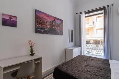a bedroom with a bed and a desk and a window at Corner Rome 433 in Palermo