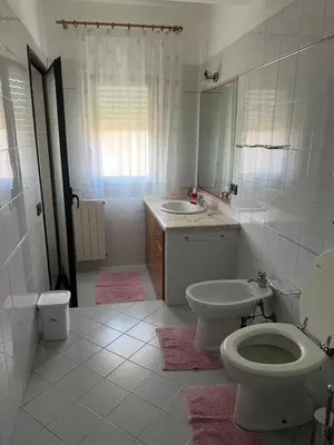 a white bathroom with a toilet and a sink at Appartamento Gemma D'oro in Castellammare del Golfo