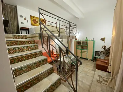 a spiral staircase in a room with a living room at Le_case_di_Antonella - your holiday in Sicilia in Castellammare del Golfo
