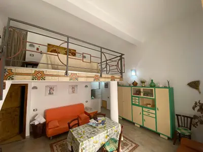 a living room with an orange couch and a loft bed at Le_case_di_Antonella - your holiday in Sicilia in Castellammare del Golfo
