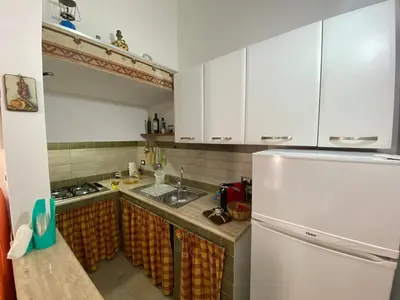 a kitchen with white cabinets and a white refrigerator at Le_case_di_Antonella - your holiday in Sicilia in Castellammare del Golfo