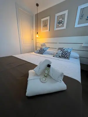 two beds with white sheets and a tie on them at Cortile dei Mori in Palermo