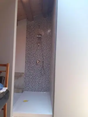 a shower in a bathroom with a tiled wall at Domus 31 in Palermo