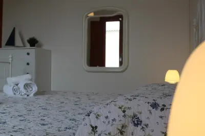 a bedroom with a bed and a mirror on the wall at Villa Fede & Niki in San Vito lo Capo