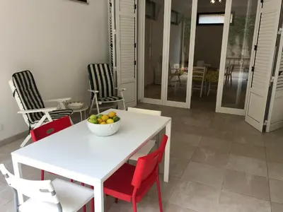 a white table and chairs with a bowl of fruit on it at Villa Fede & Niki in San Vito lo Capo