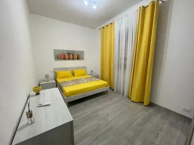 a bedroom with a yellow bed and yellow curtains at OUR BEAUTIFUL SICILY in Palermo