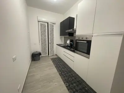 a small kitchen with white cabinets and a refrigerator at OUR BEAUTIFUL SICILY in Palermo