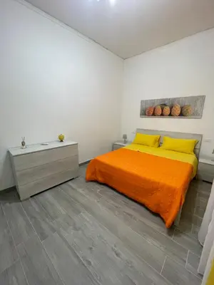 a bedroom with a bed with an orange blanket at OUR BEAUTIFUL SICILY in Palermo
