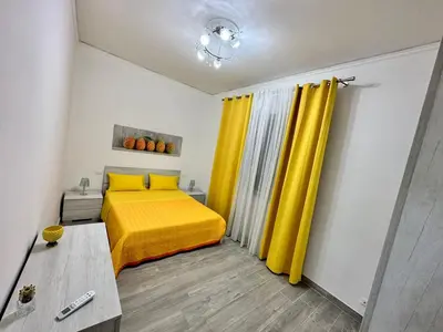 a bedroom with a yellow bed and yellow curtains at OUR BEAUTIFUL SICILY in Palermo
