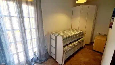 a small bed in a room with two windows at A Casa di Sasy in Palermo