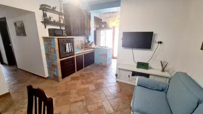 a living room with a blue couch and a tv at A Casa di Sasy in Palermo