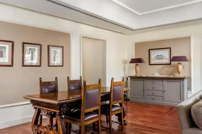 a dining room with a table and chairs and a couch at Eurostars Centrale Palace Hotel in Palermo