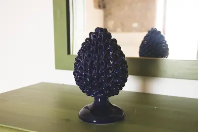 a black pineapple vase sitting on a table at Masseria Baglio Perciata in Camporeale