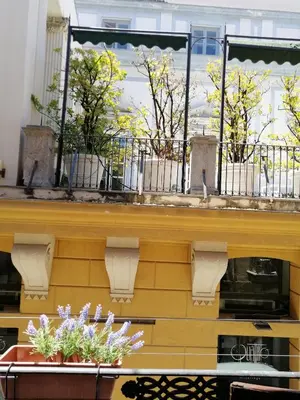 a balcony with a table and flowers on it at Casa Dadà, romantic house in historic centre in Palermo