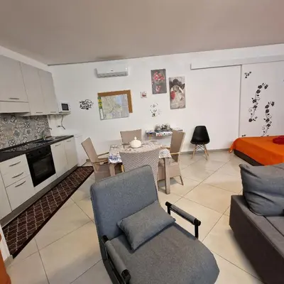 a kitchen and living room with a couch and a table at Aspettando Vossia in Palermo
