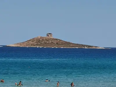 people on the beach with an island in the water at Casetta delle Mimose in Isola delle Femmine