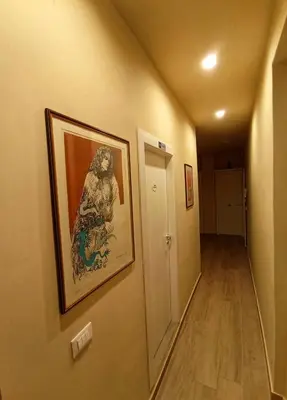 a hallway with a painting of a woman on the wall at Donna Franca Rooms and Suite in Palermo