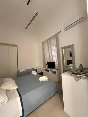 a hotel room with two beds and a mirror at Casetta Mape in Palermo